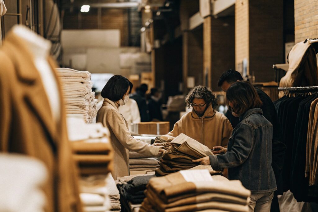 Fashion buyers inspecting wholesale apparel in a clothing warehouse