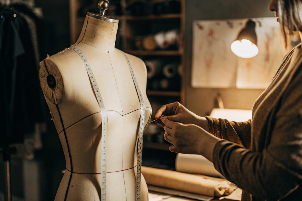 Fashion designer working on a dress form with measuring tape