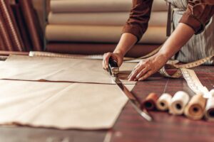 Tailor cutting fabric with precision in a textile workshop
