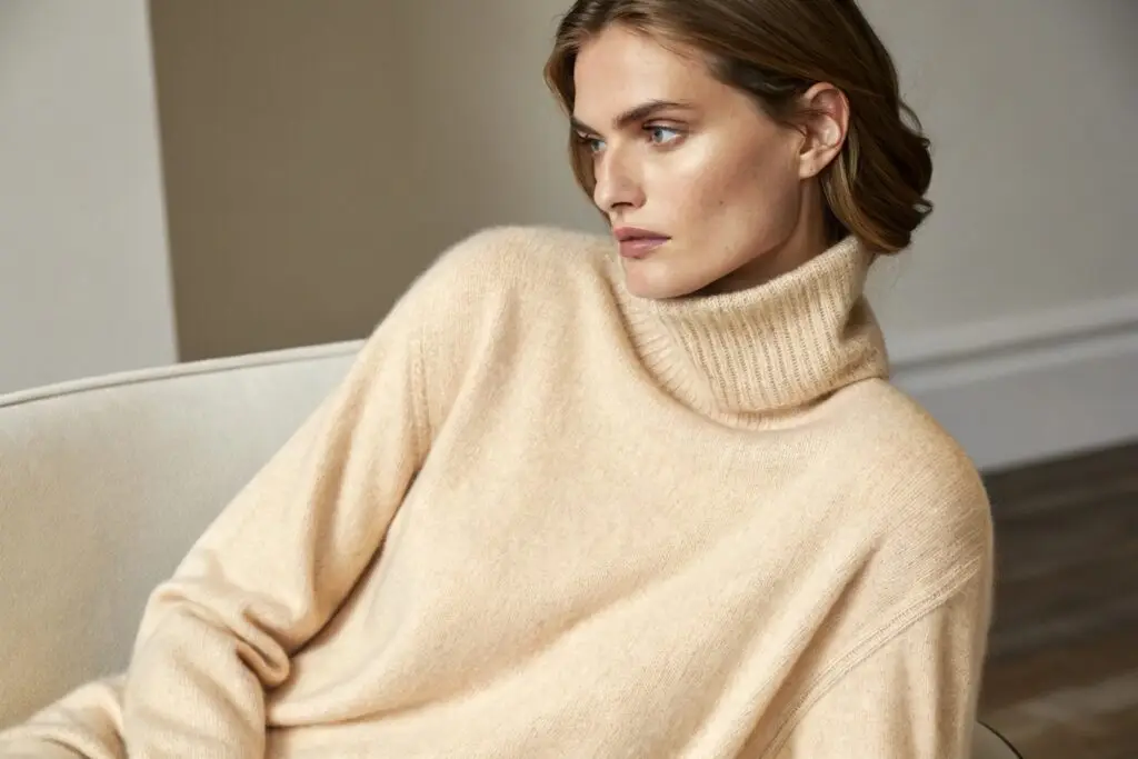 Woman wearing a cozy beige cashmere sweater, perfect for cold weather