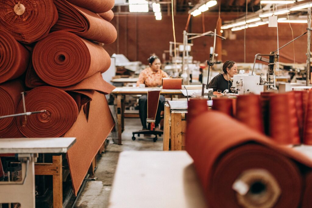 Modern clothing factory with workers handling fabric and sewing garments