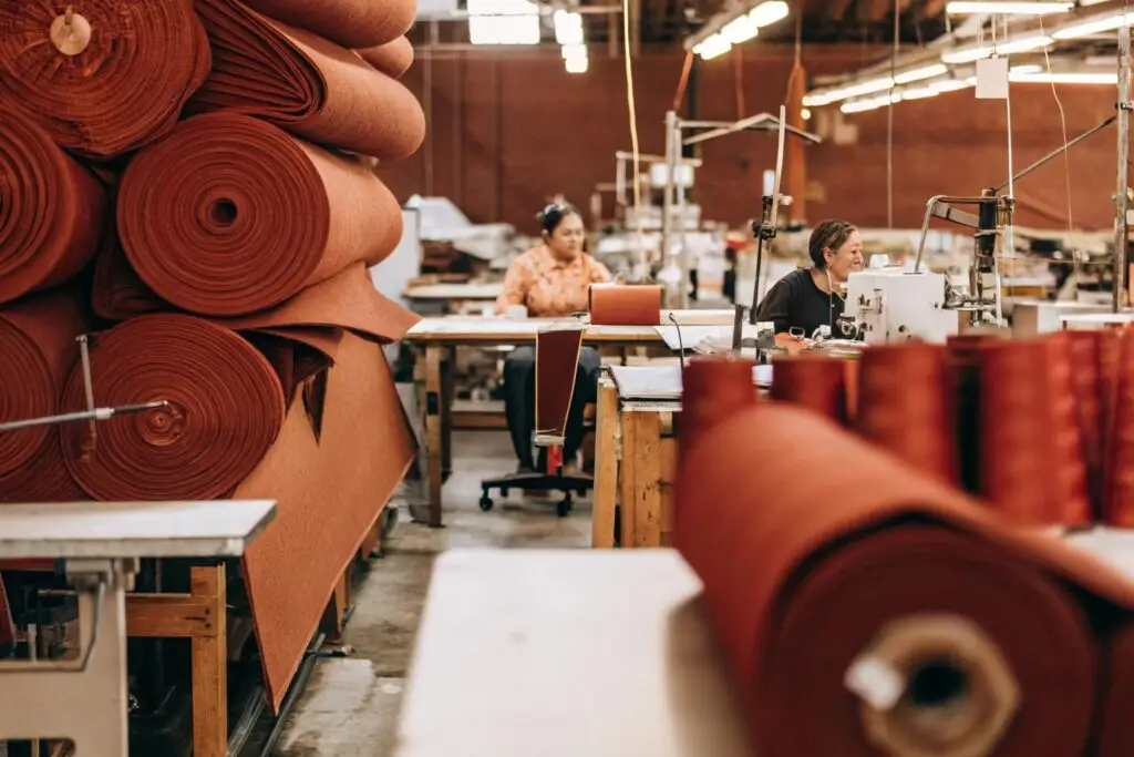 Modern clothing factory with workers handling fabric and sewing garments