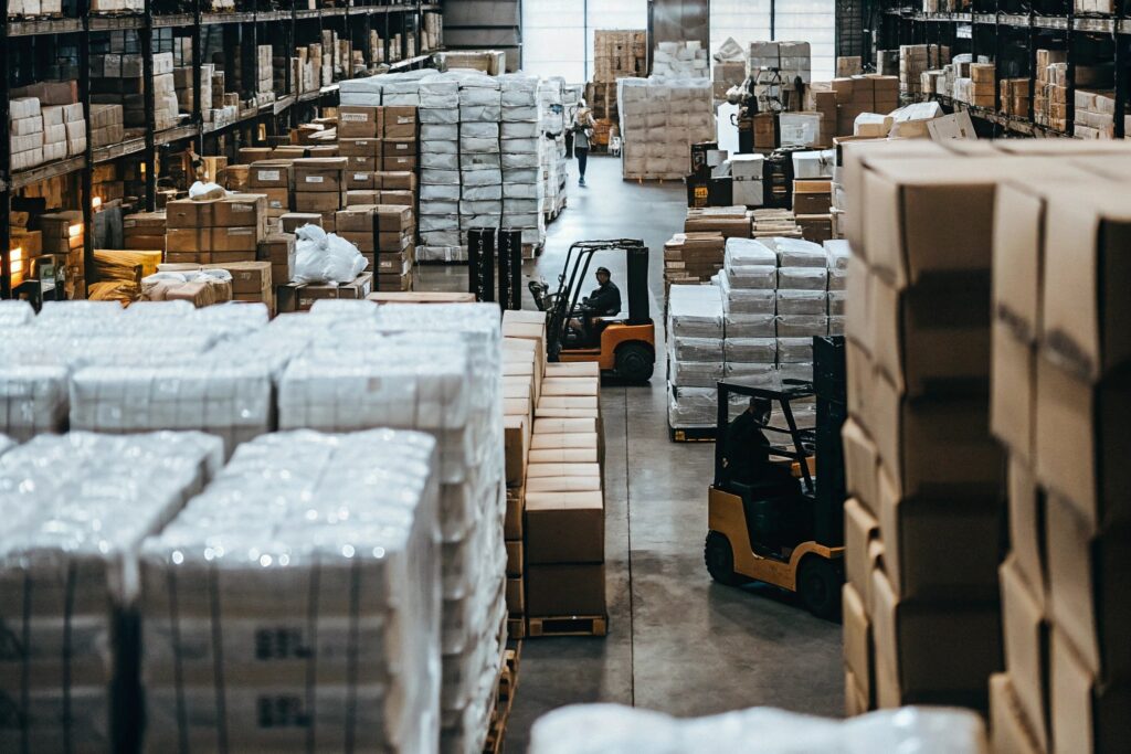 Large-scale clothing wholesale warehouse with forklifts and packed inventory