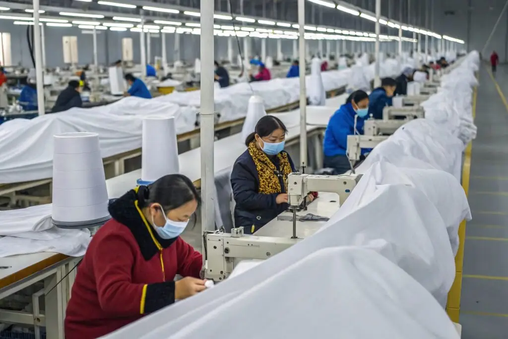 Workers sewing garments in a high-capacity production factory