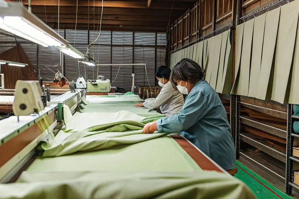 Workers in a modern apparel factory carefully handling fabric, ensuring precision in garment production.