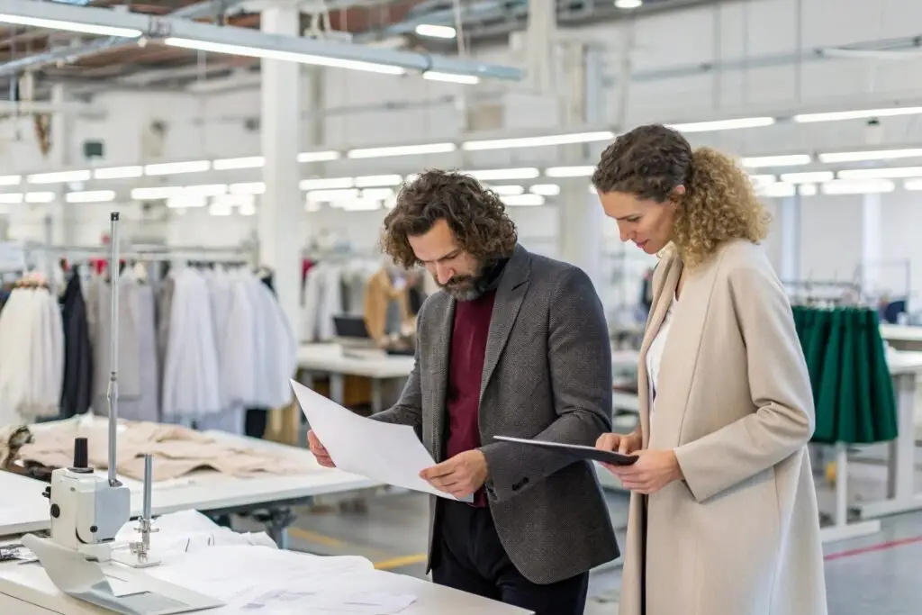 Fashion designers reviewing sketches in a garment factory
