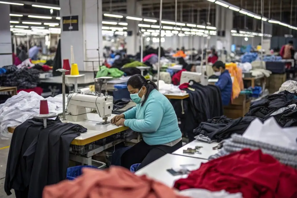 Workers sewing garments in a large clothing factory