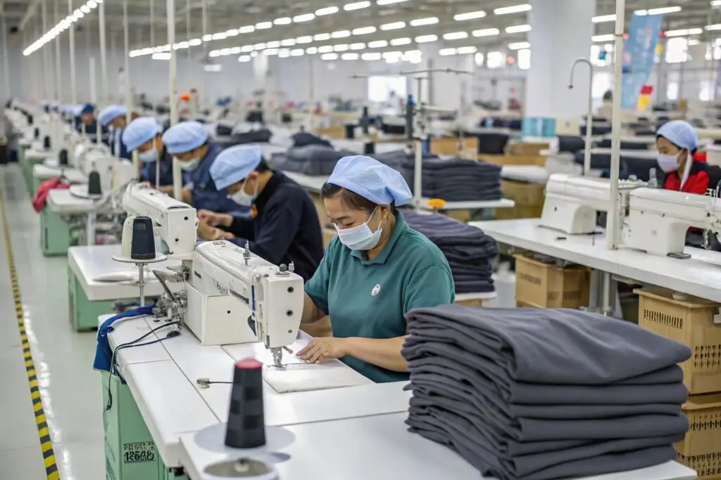 Garment factory workers sewing clothing in mass production