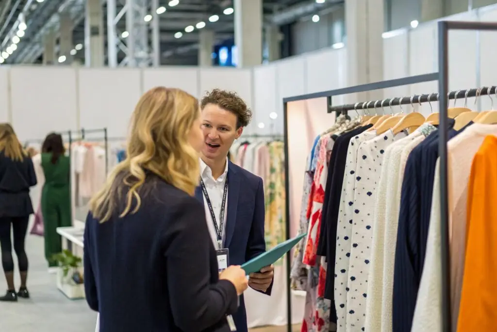 Fashion trade show meeting between clothing brand owner and buyer
