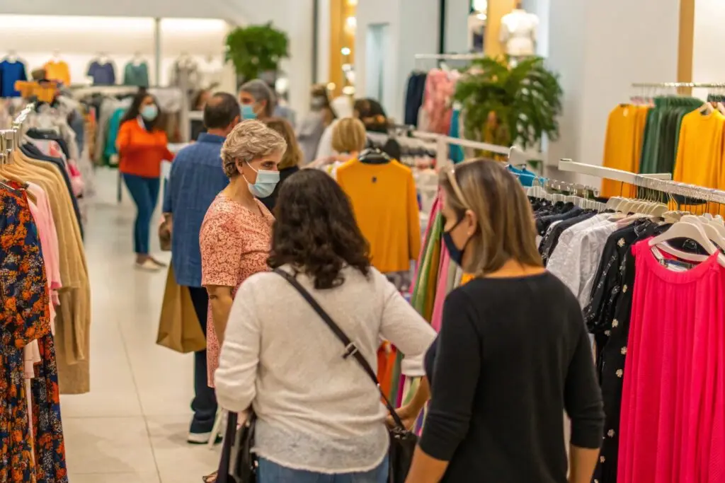 Shoppers browsing clothing racks in a busy fashion store