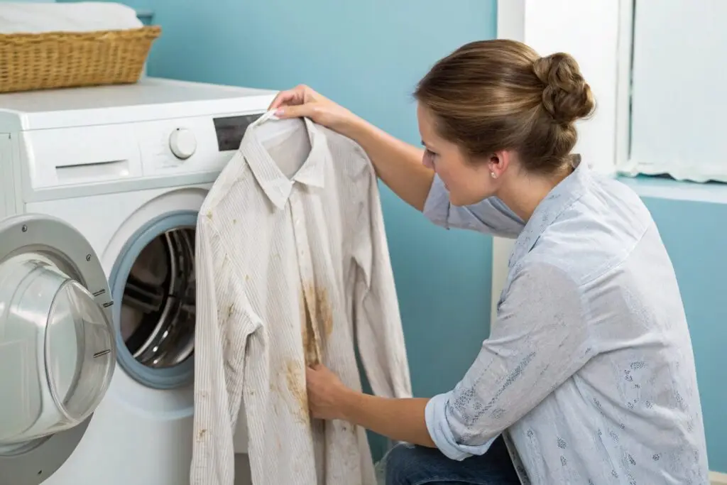 Woman inspecting stained shirt, laundry problem