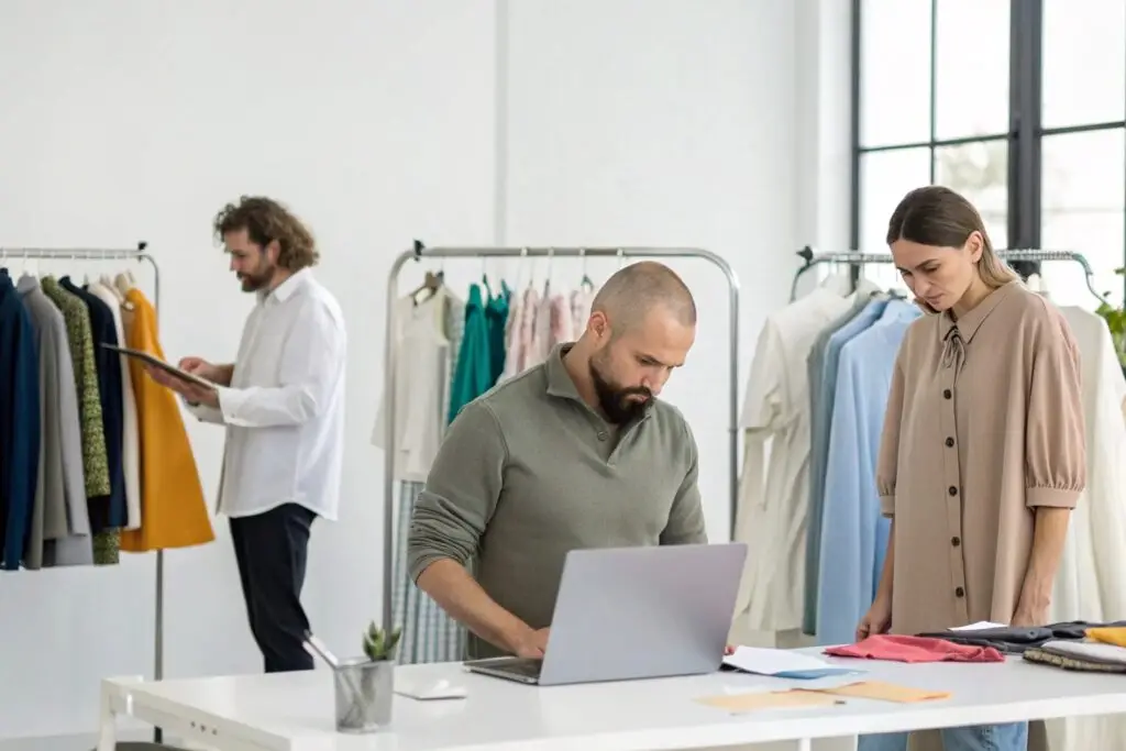 Fashion professionals reviewing clothing samples and notes