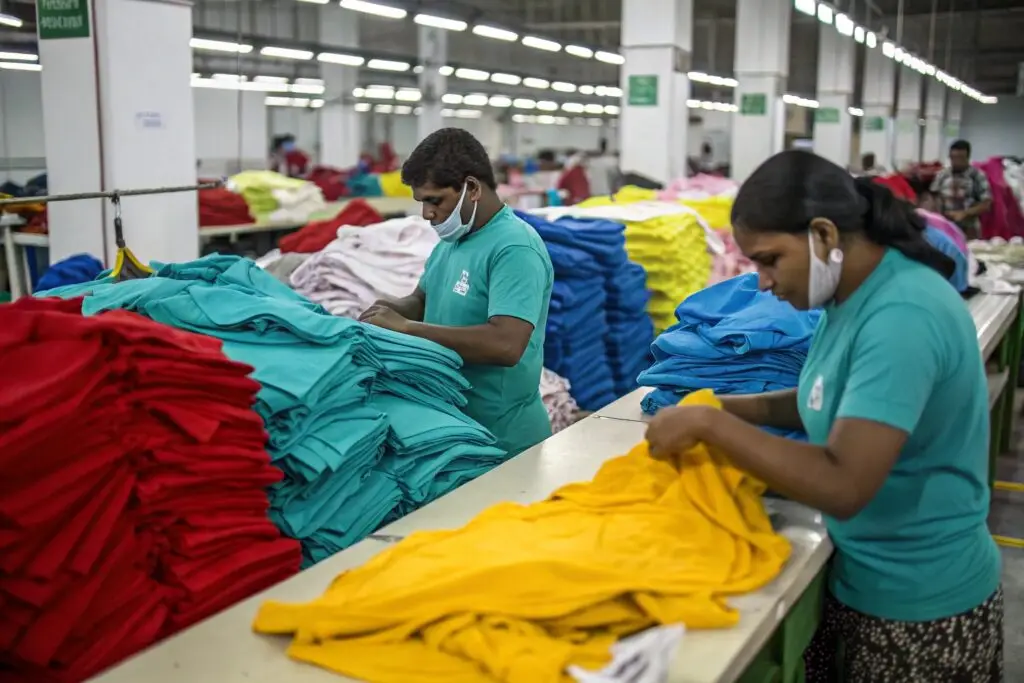 Workers in a textile manufacturing facility inspecting colorful garments