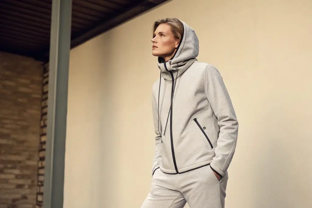 Model in a gray tech fleece tracksuit