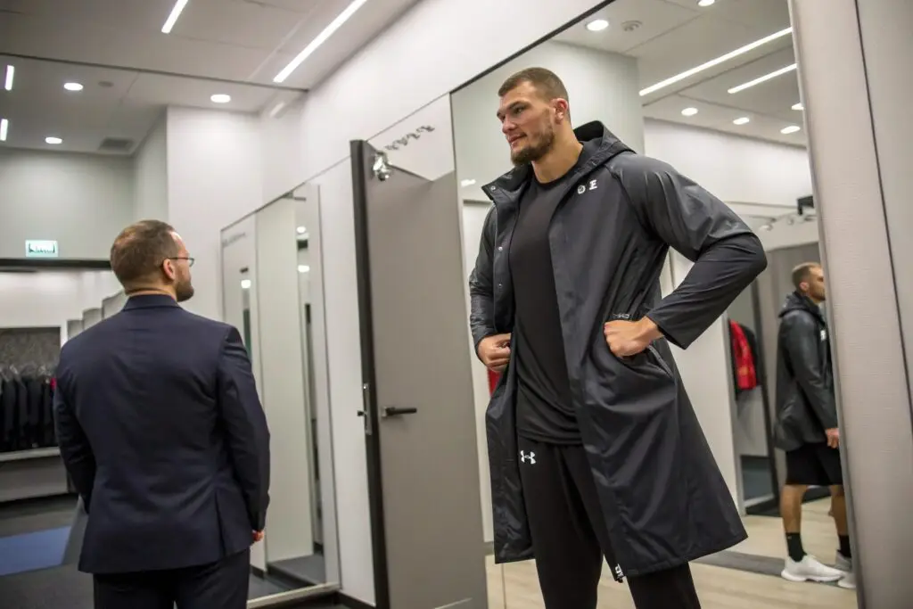 Tall athlete trying on tailored sportswear coat