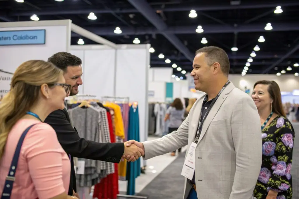 Apparel entrepreneur networking with wholesale partners at trade show