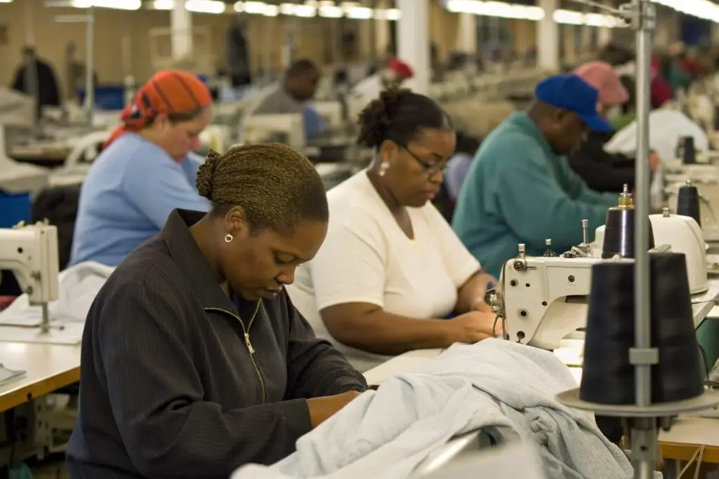 Workers focused on garment sewing in a busy American clothing factory