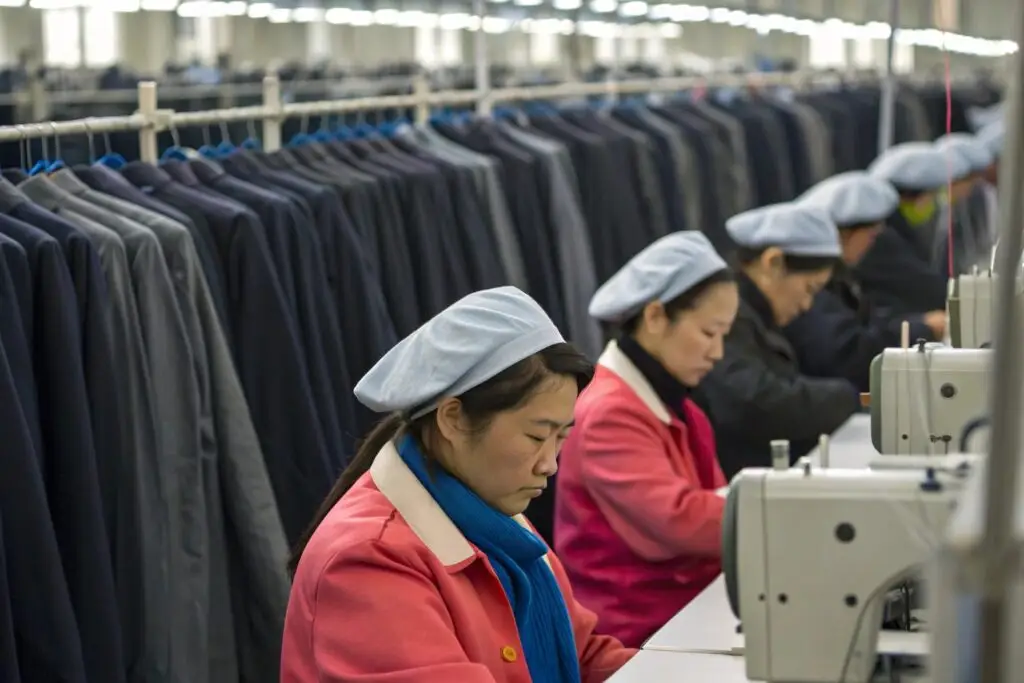 Workers in a Chinese garment factory sewing clothing on the production line