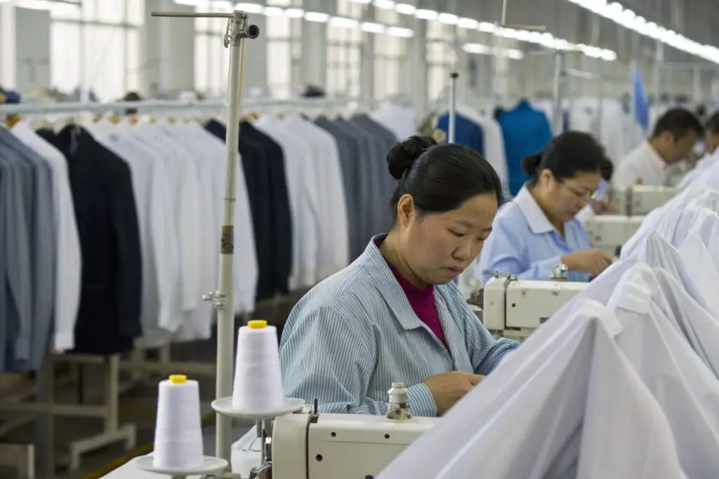 Workers sewing garments in a large factory