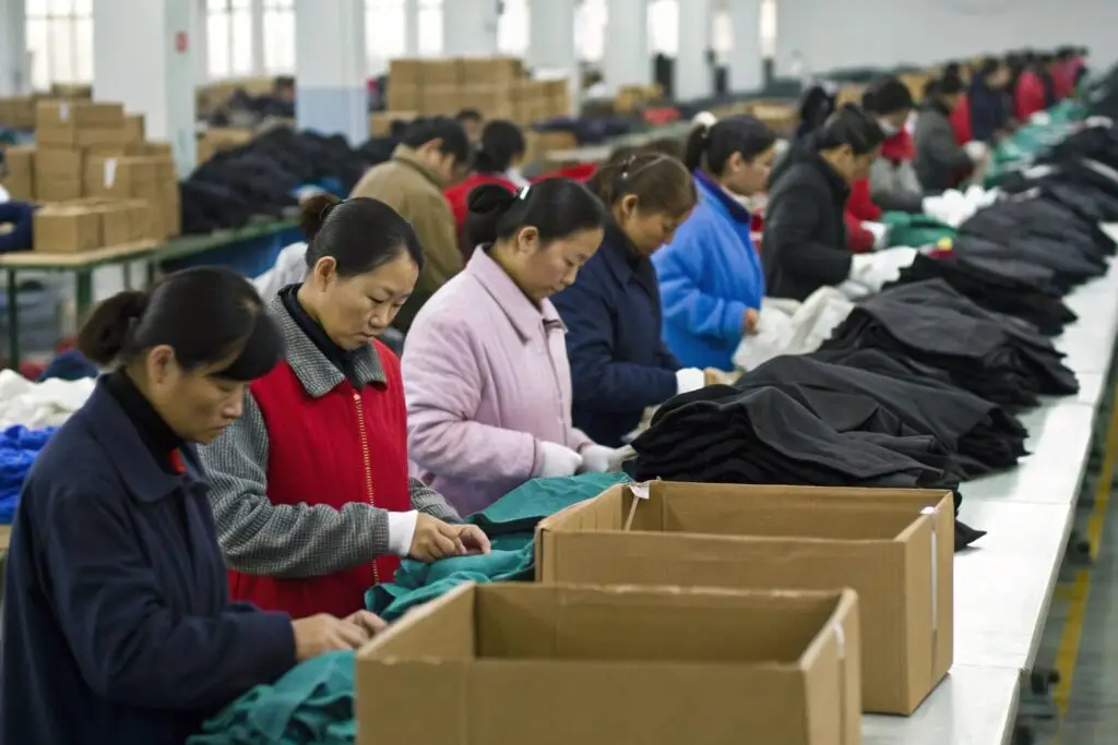 Workers inspecting and folding garments for packaging