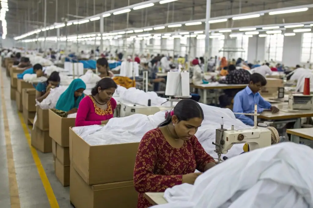 Garment workers stitching clothes in a busy factory