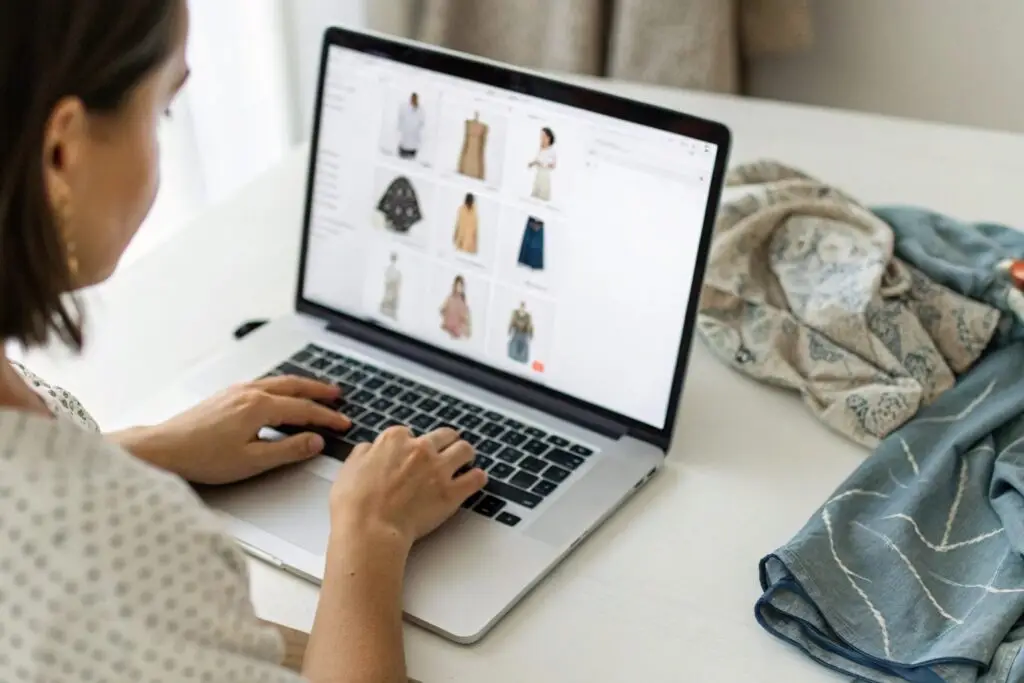 Western fashion entrepreneur browsing online clothing catalog on laptop