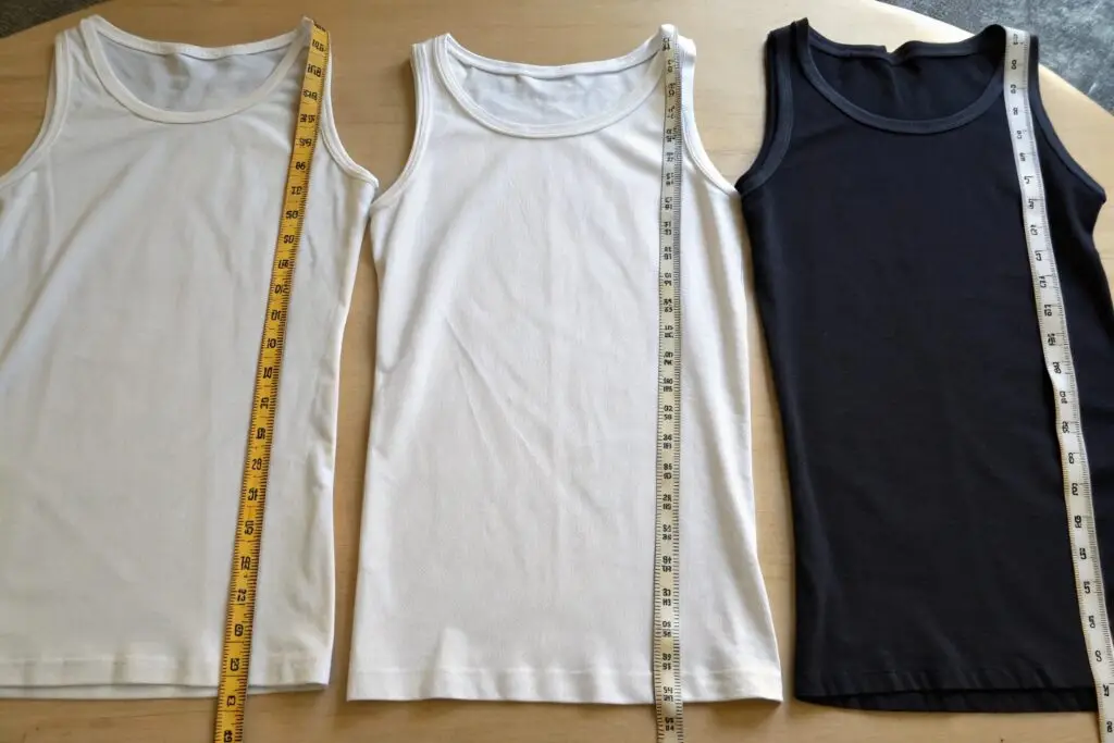 white and black tank tops with measuring tape laid out flat