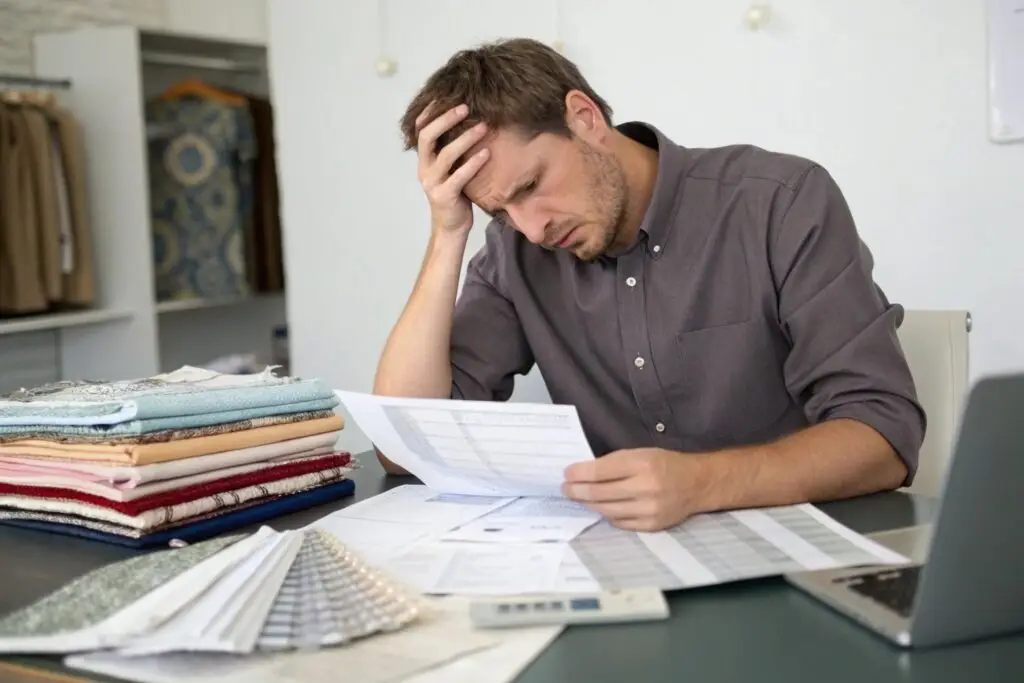 Frustrated fashion sourcing manager reviewing textile costs